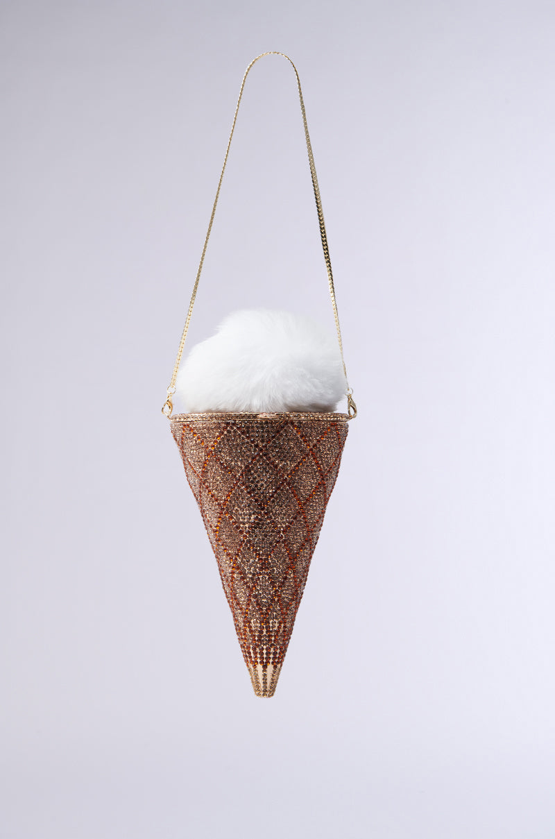 The LICK IT UP FAUX FUR ICE CREAM BAG is a novelty purse with a beaded waffle-texture design featuring rhinestones. It resembles a fluffy faux-fur ice cream scoop and includes a thin gold shoulder strap against a plain gray background. 0