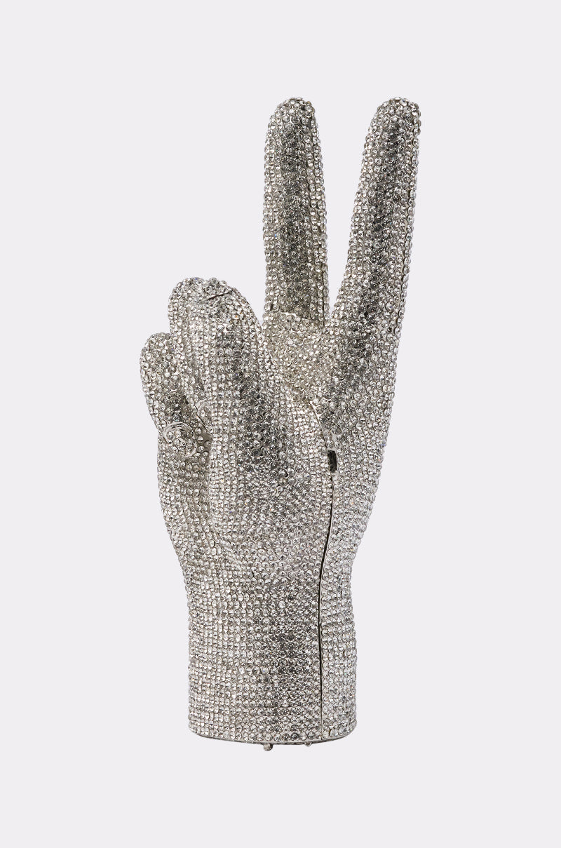 The PEACE BLING PURSE is a sparkling silver handbag shaped like a peace-sign hand and covered in rhinestones, displayed against a light gray background. 3