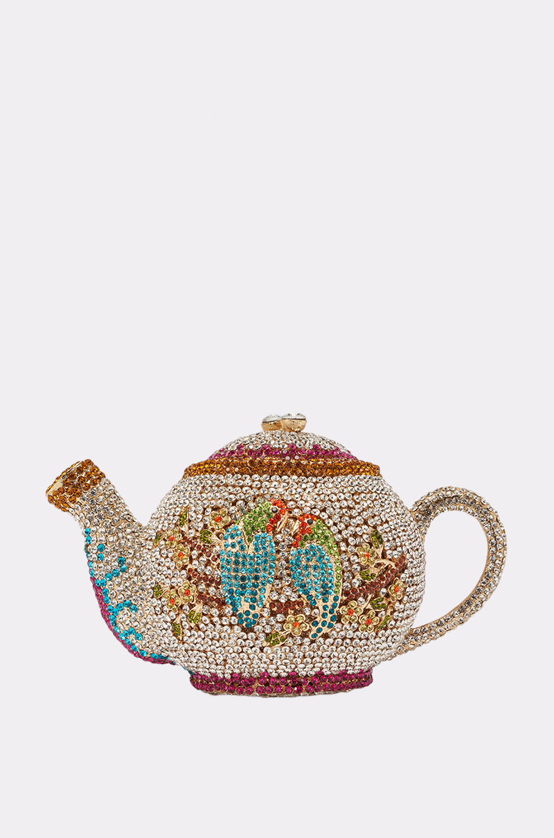 The WHATS THE TEA BLING PURSE is a whimsical novelty handbag designed as a jeweled rhinestone teapot with colorful stones, blue birds, and floral accents, showcased elegantly against a plain white background. 1