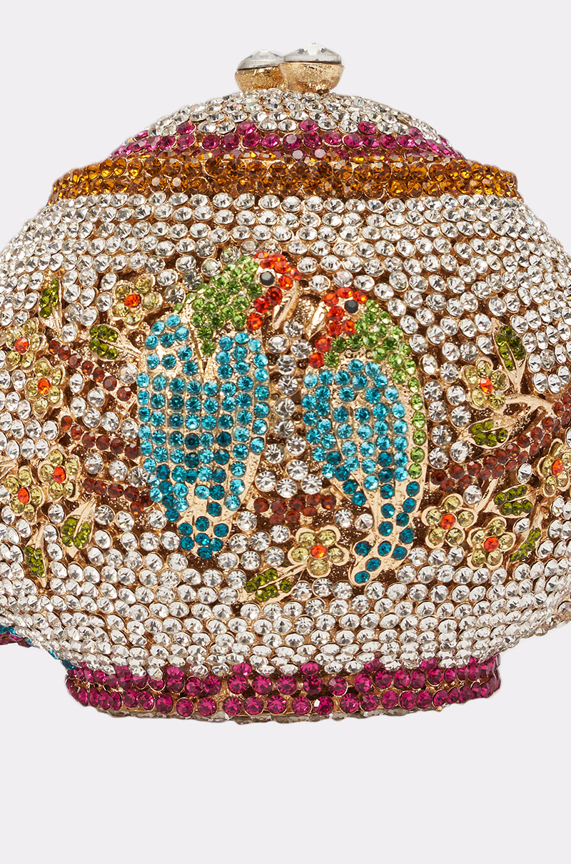 The WHATS THE TEA BLING PURSE is a jeweled clutch decorated with colorful crystals, featuring two blue and green birds facing each other amid floral motifs and gold accents—perfect for evening parties. 4
