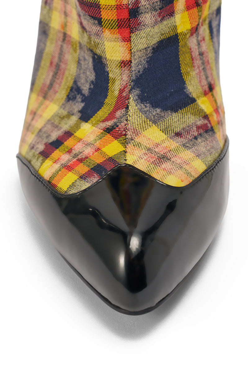 Close-up of the pointed toe of the AKIRA WANG LOCHANA MULTI YELLOW PLAID FLANNEL SEXY BOOT, showcasing a glossy black patent leather tip and a vibrant plaid pattern in yellow, red, blue, and beige. 8