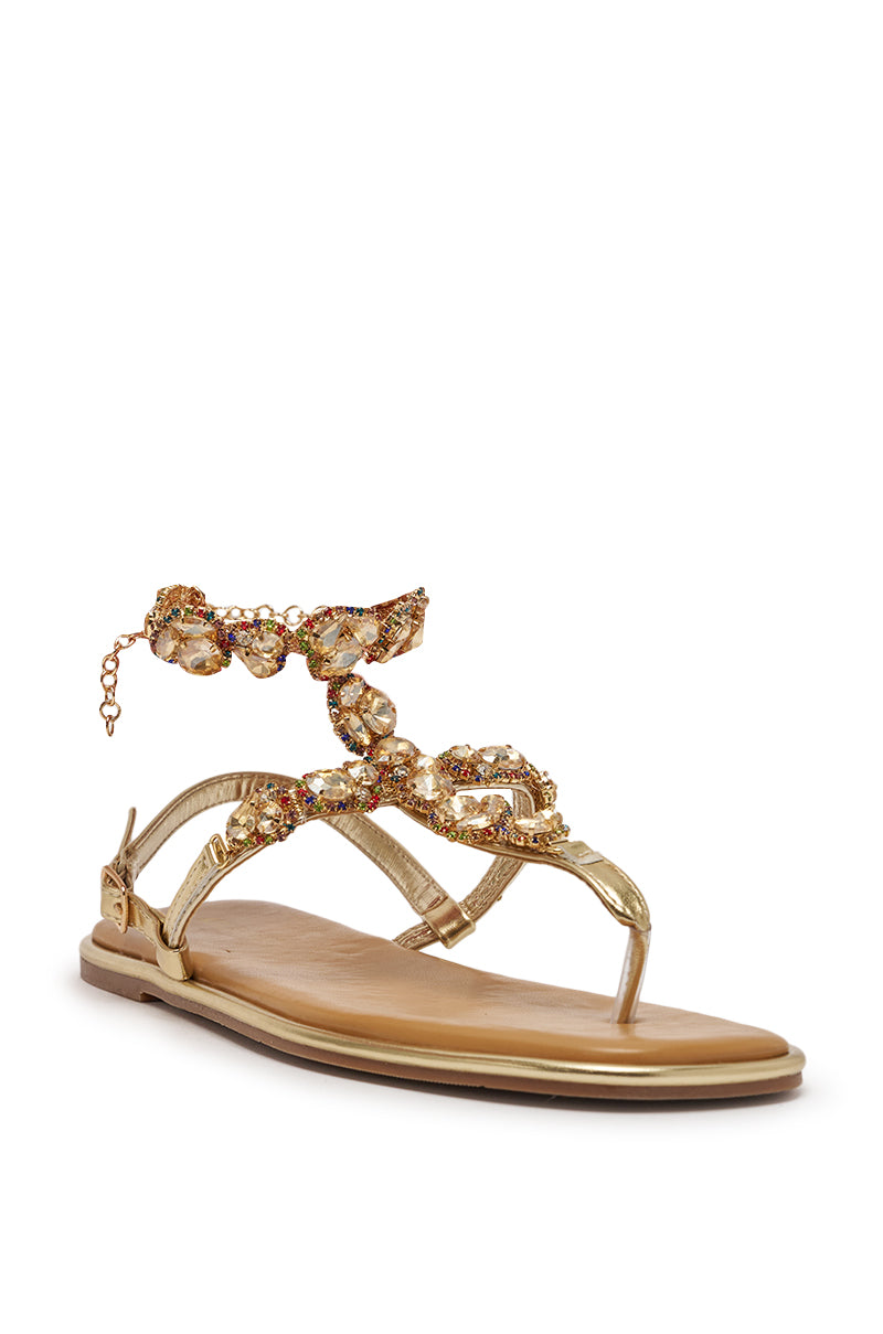 The AZALEA WANG LOSKI Gold Metallic Flat Strap Sandal features a tan sole, jeweled T-strap with rhinestone embellishments, sparkling crystals, and a decorative ankle chain. 3