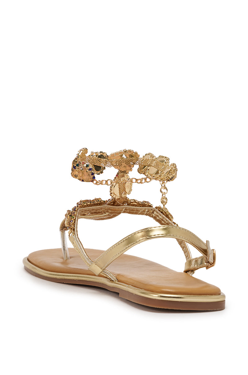 The AZALEA WANG LOSKI Gold Metallic Flat Strap Sandal features a tan sole, rhinestone-embellished T-strap, and decorative gold embellishments across the ankle and instep. 4