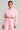 Wearing the LOVER CROPPED HOODIE along with coordinating sweatpants, the individual stands against a simple backdrop. Holding a red purse and adorned with hoop earrings, their hair is pulled back, completing a stylish monochrome look.