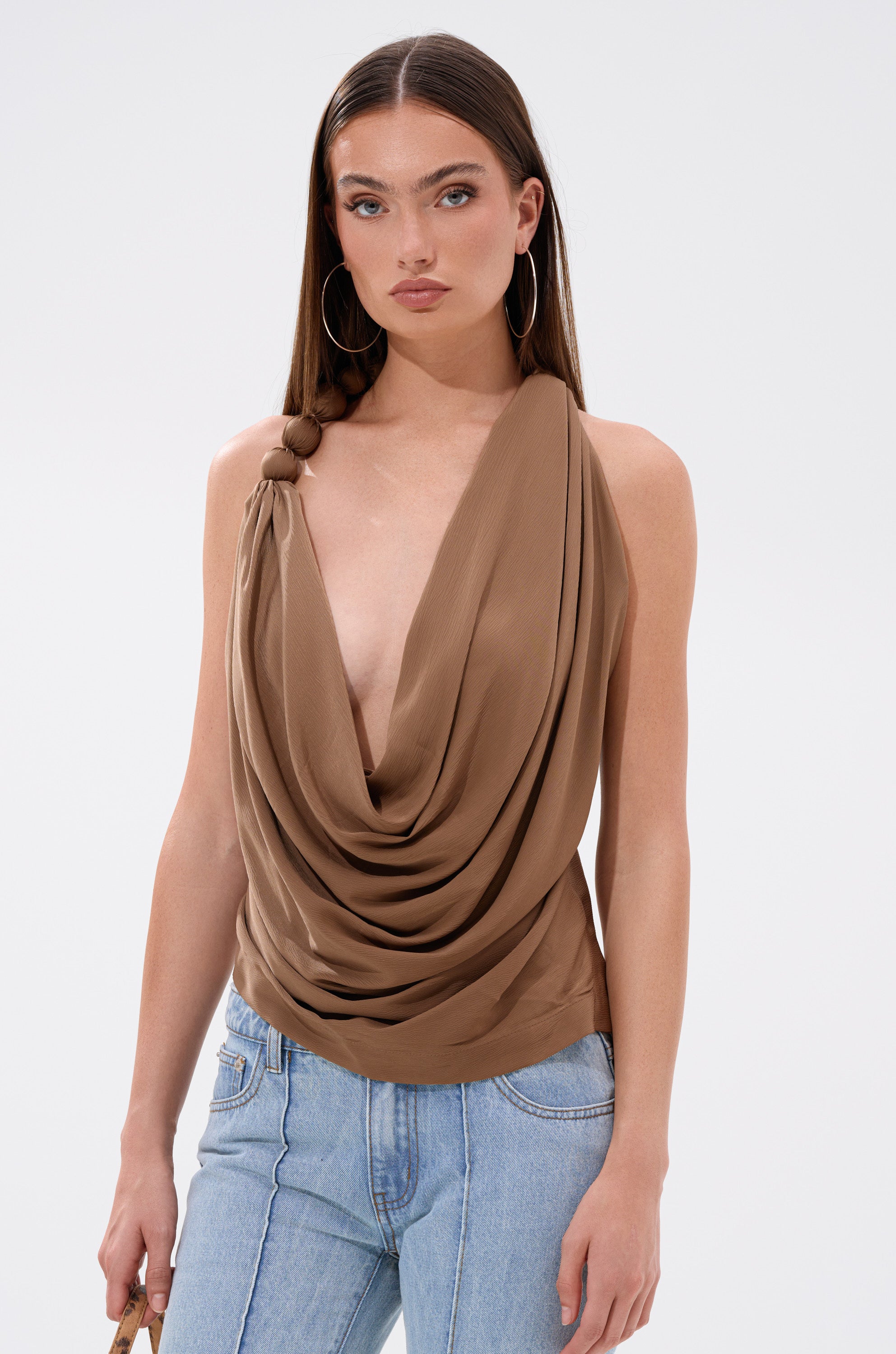 A woman poses for a picture, elegantly dressed in the LEXI SATIN COWL NECK BLOUSE.