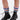 Close-up of a person's lower legs wearing the AZALEA WANG LUBNA BLACK FABRIC DETAIL BOOTIE with chunky rubber soles and colorful ruched leg warmers in pink, blue, green, and white, standing on a white background.