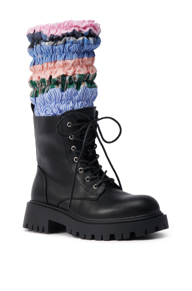 The AZALEA WANG LUBNA BLACK FABRIC DETAIL BOOTIE is a black lace-up combat boot with a chunky rubber sole and vibrant pink, blue, and green striped, ruched fabric layers ruffling from the top.
