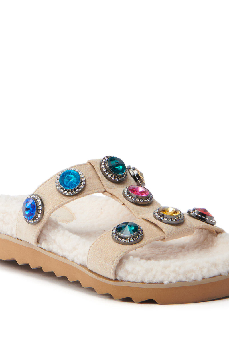 The AZALEA WANG LUCIENA Beige Sandal features colorful round gemstones on the straps, a fluffy white sherpa-like footbed, a textured brown sole, and elegant suede foot bands.