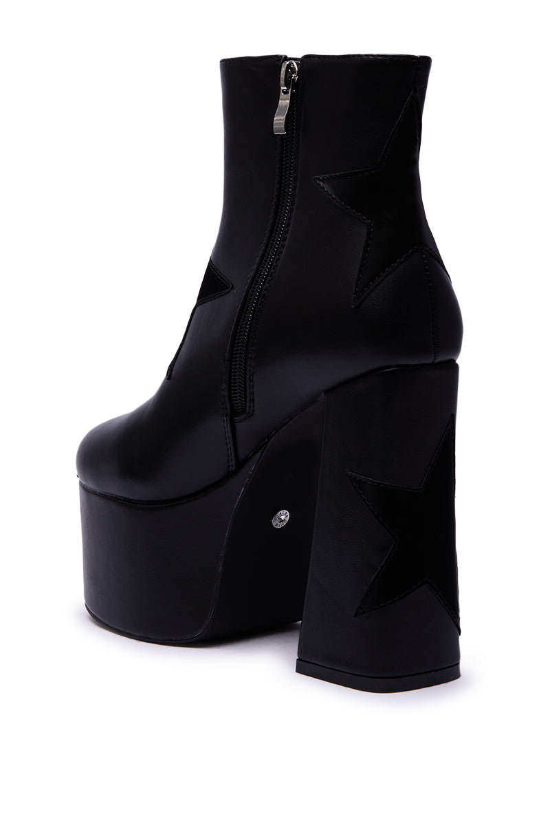 The AZALEA WANG LUKYIE BLACK STAR DETAIL PLATFORM BOOTIE features a chunky heel, side zipper, and star accents on the heel and side, crafted from shiny black faux leather for a bold statement.