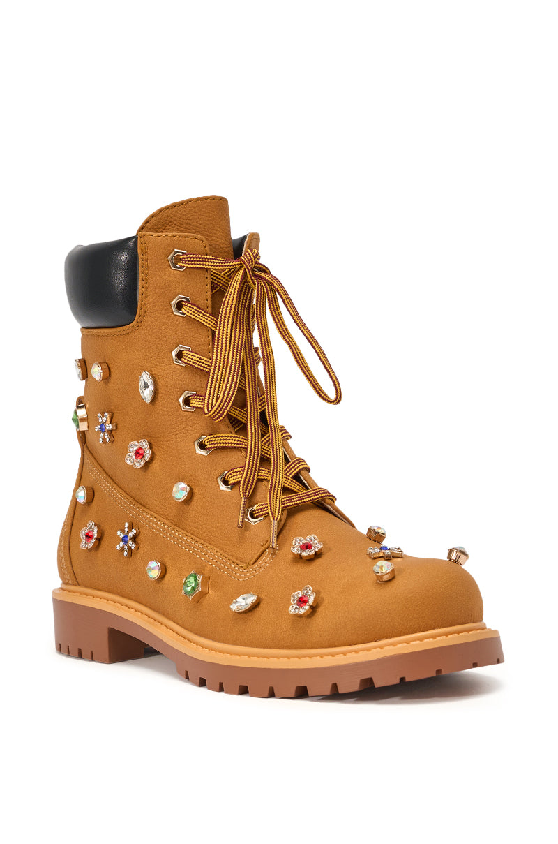 The AKIRA GOLD LUSTER TAN EMBELLISHED FLAT COMBAT FESTIVAL BOOTIE features a tan lace-up design, rugged sole, black padded collar, and colorful rhinestone decorations for bold festival style, shown on a white background. 5