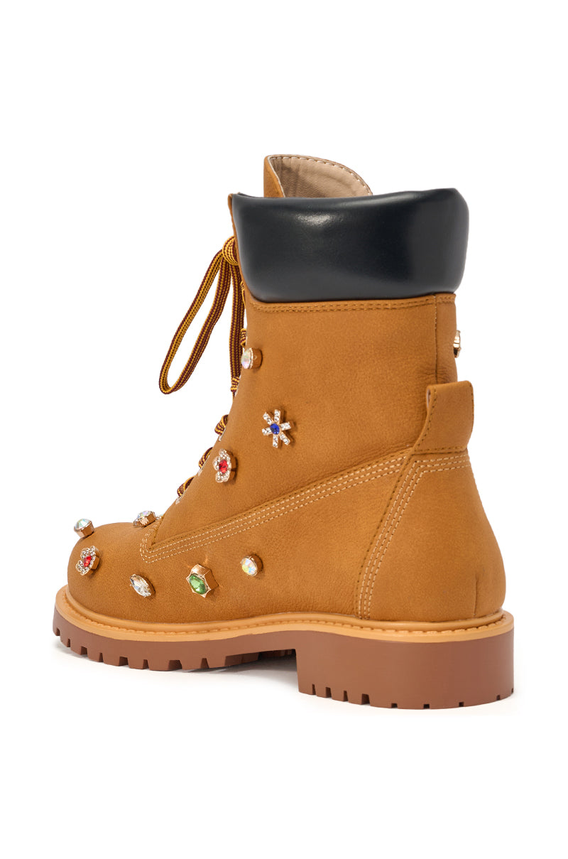 Step out in style with the AKIRA GOLD LUSTER TAN EMBELLISHED FLAT COMBAT FESTIVAL BOOTIE, featuring tan faux leather, a thick sole, black padded collar, and colorful rhinestone accents—perfect for making a statement at any festival. 6