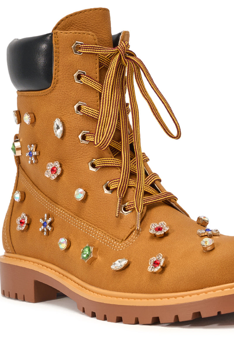 The AKIRA GOLD LUSTER TAN EMBELLISHED FLAT COMBAT FESTIVAL BOOTIE is a tan lace-up combat bootie with a thick sole, black padded collar, and vibrant rhinestone and jewel accents for bold street style. 7