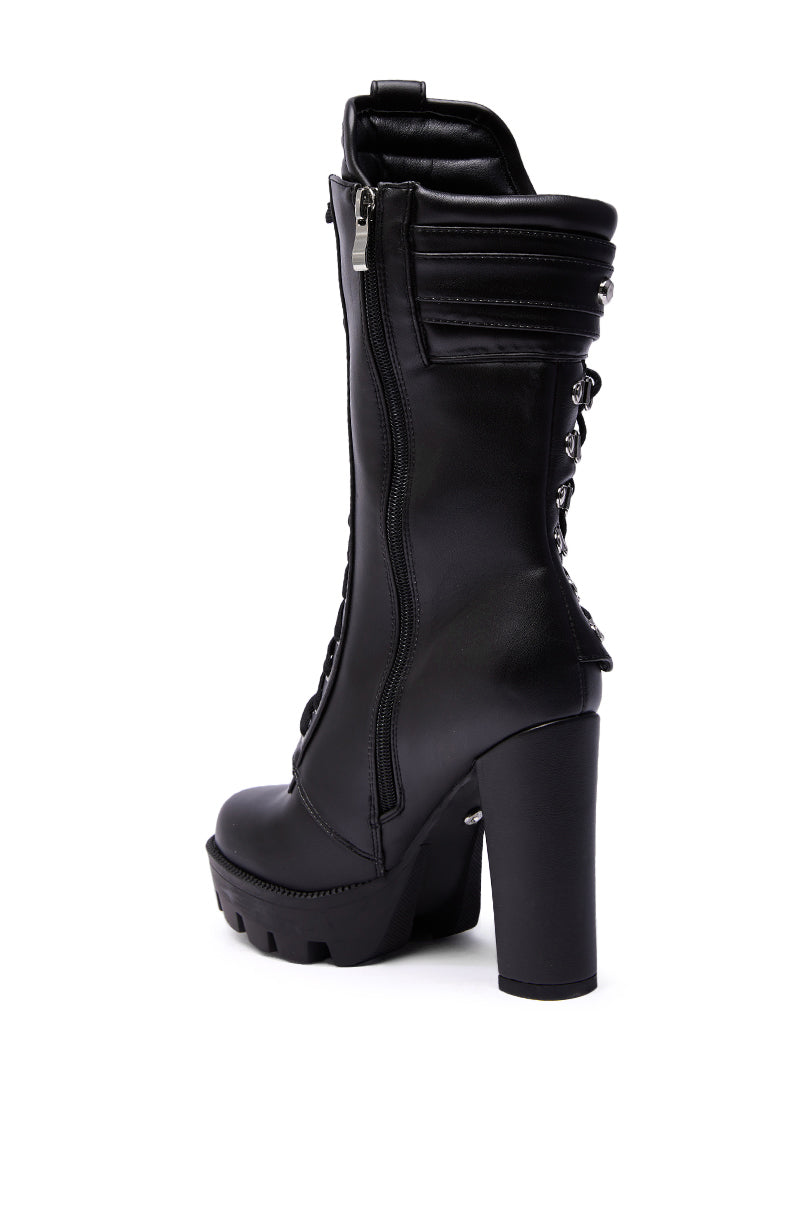 The AZALEA WANG LUUK Black Metal Hardware Embellished Chunky Bootie features black faux leather, a chunky platform sole, side zipper, metal hardware accents, and back lace-up detail, displayed against a white background.