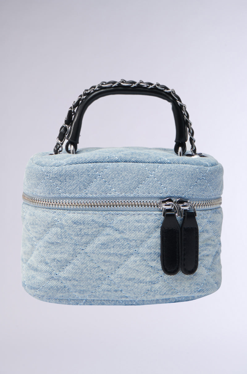 The CHACHA DENIM MINI PURSE features a quilted design with two black leather zipper pulls and a short handle with a black chain detail, all set against a light gradient background for a chic touch.