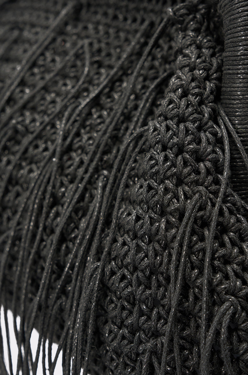 Close-up of the IN THE WIND CLUTCH, a black purse with intricate crochet patterns and long fringe—an eye-catching accessory perfect for a girls’ night out. 3