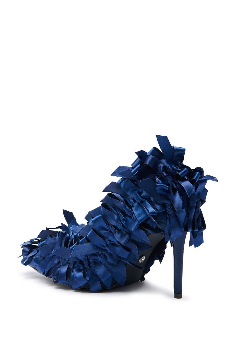 The AZALEA WANG LYLIO NAVY BOW EMBELLISHED PUMP features multiple dark blue satin bows, a pointed toe, and an elegant stiletto heel, displayed against a white background.