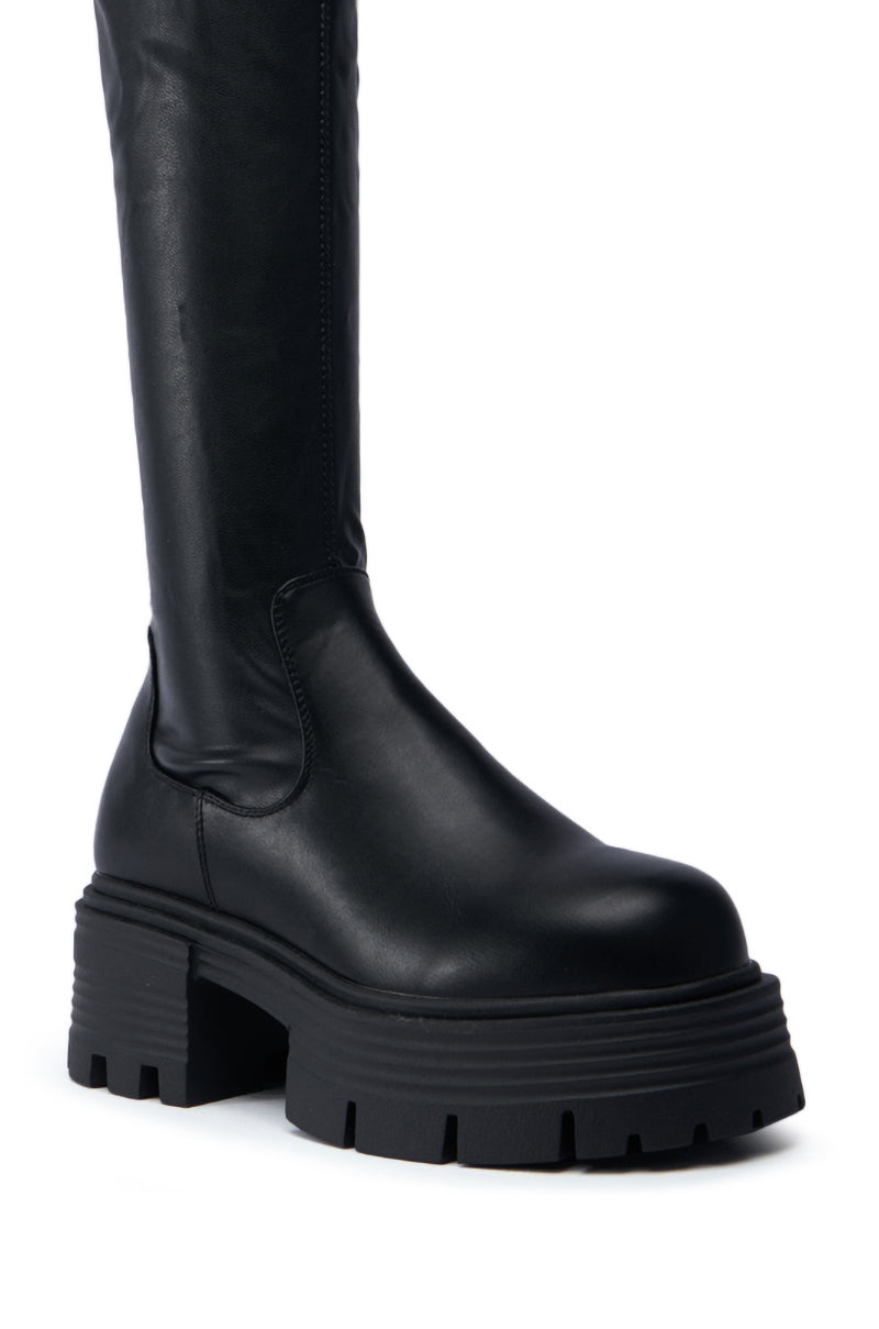 A close-up of the SLIM FIT AZALEA WANG LYNX BOOT WITH 4 WAY STRETCH IN BLACK, showcasing its knee-high shaft with a chunky heel and smooth leather finish. The boot includes an elevated platform and sleek, minimalist design, providing a refined twist on classic slim fit boots.