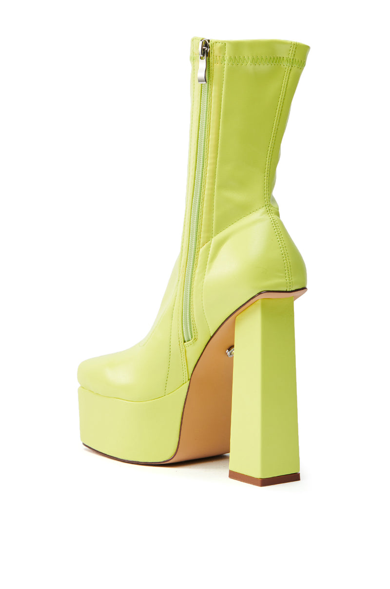 The AZALEA WANG MADDER LIME PLATFORM BOOTIE is a lime green faux leather bootie featuring a side zipper, thick sole, and chunky heel with a glossy finish, showcased upright against a white background.