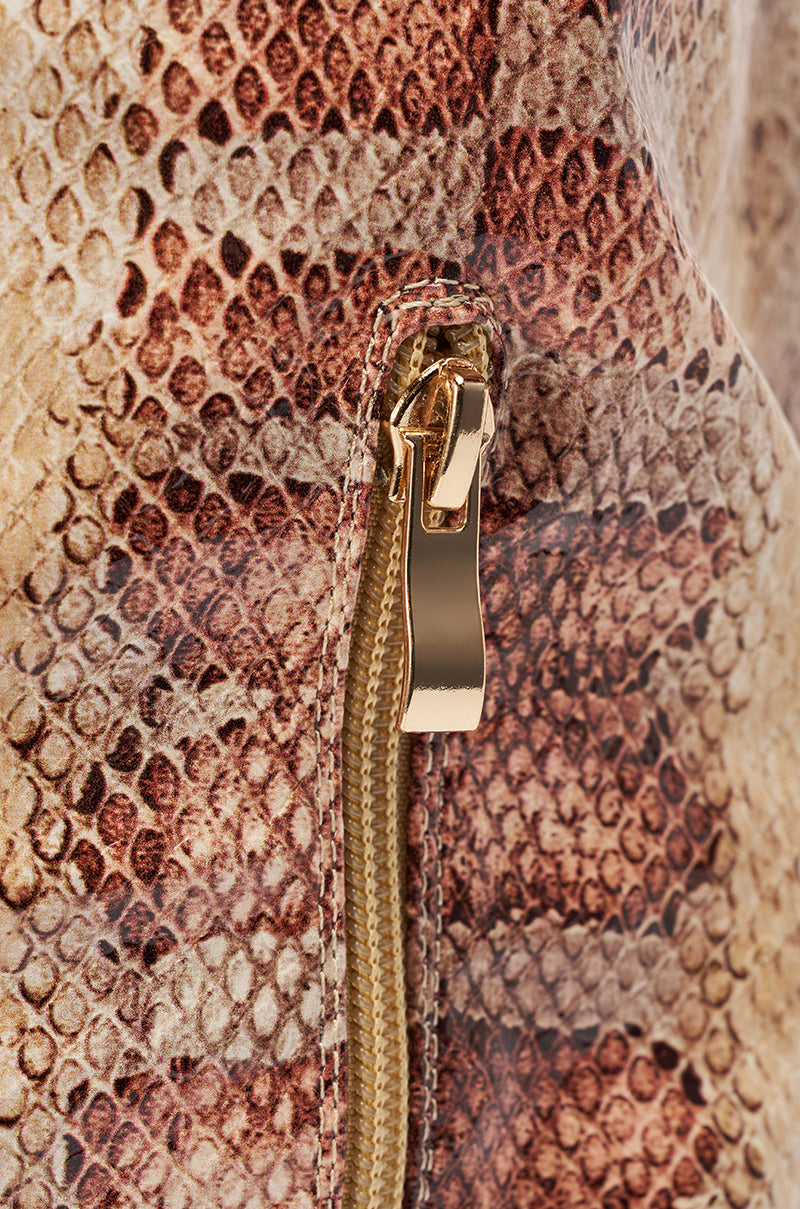 Close-up of a gold zipper on brown and beige snakeskin-patterned fabric, inspired by the AZALEA WANG MADEYE NUDE SNAKE STILETTO BOOT. 10
