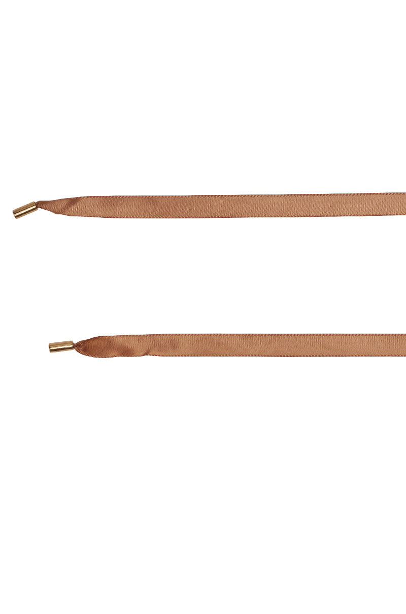 Two light brown, flat satin shoelaces with metallic gold aglets are displayed horizontally on a white background, making them an ideal match for the AZALEA WANG MADHAV BRONZE RHINESTONE AND FOX FUR SANDAL.