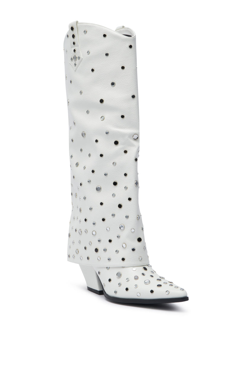 The AZALEA WANG MADLOCK WHITE EMBELLISHED WESTERN BOOT is a tall, slouchy white leather Western boot featuring a pointed toe, low angled heel, and silver studs and grommets for an authentic Rhinestone Cowgirl style.