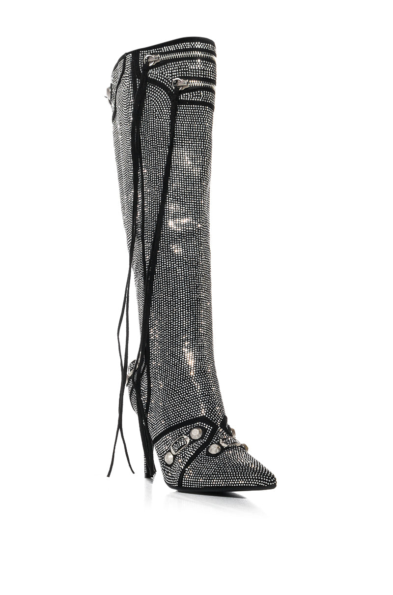 The AZALEA WANG MAEVE SILVER STILETTO BOOT dazzles with its knee-height glittering rhinestone-embellished shaft, black laces, and decorative studs, all perched on a sleek stiletto heel.
