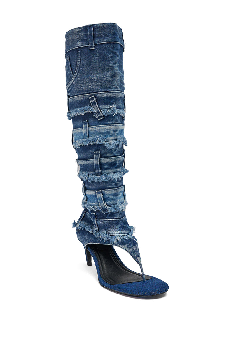 The AKIRA GOLD MAHONEY DENIM PANT DETAIL GLADIATOR STILETTO, a blue high-heeled boot, is shown with Taipei 101 in the background. 5