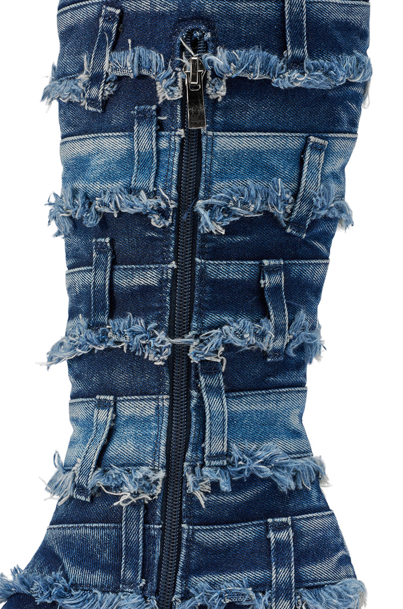 Close-up of the AKIRA GOLD MAHONEY DENIM PANT DETAIL GLADIATOR STILETTO showing blue denim fabric with a black zipper and multiple horizontal frayed seams for a textured, layered look. 7