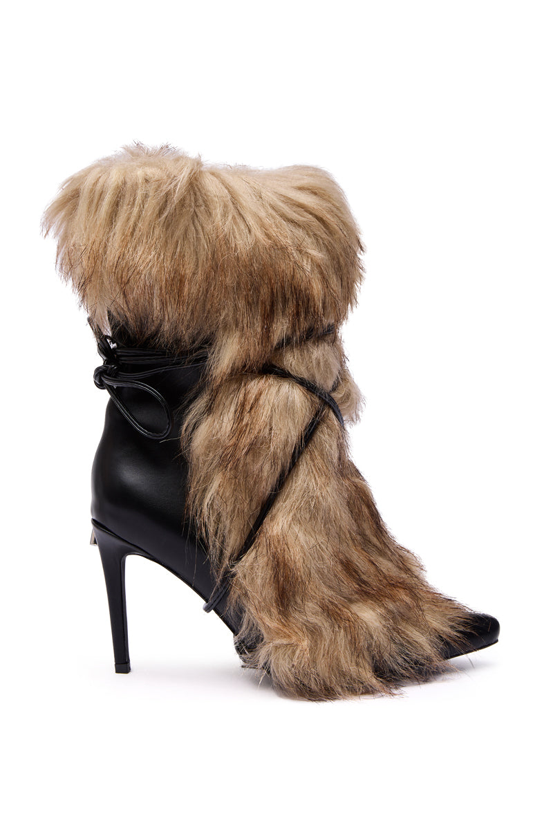 The AZALEA WANG MAHTAMA BLACK FUR EMBELLISHED BOOTIE features high heels, black faux leather, thick shaggy brown faux fur, a pointed toe, and lace detail at the ankle.