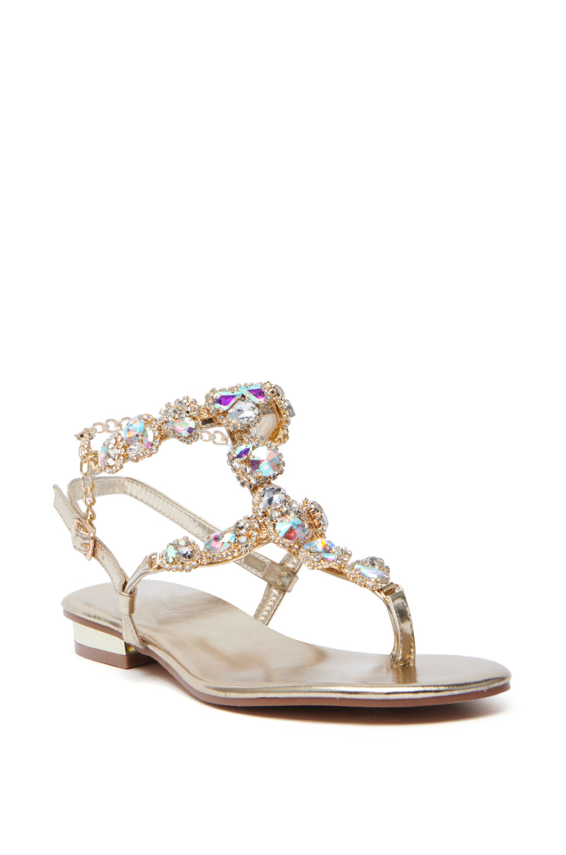 The AZALEA WANG MANAIA GOLD EMBELLISHED SANDAL features a metallic gold PU design with a low heel and intricate rhinestone-adorned straps. This open-toe sandal dazzles elegantly, offering both style and allure.