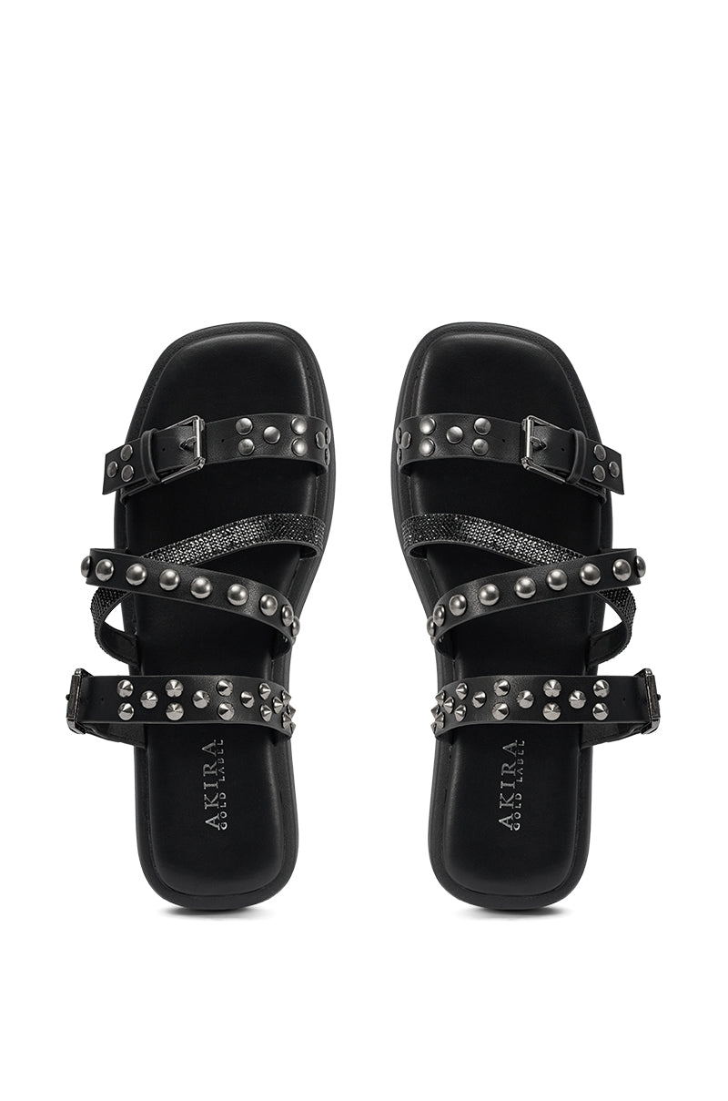 The AKIRA GOLD MANNING BLACK HARDWARE EMBELLISHED FLAT SANDAL features black studded slide design with three adjustable buckle straps and a cushioned footbed, shown side by side on a white background. 2