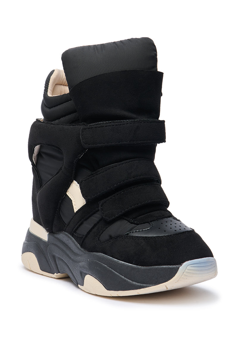 The MARANTO CHUNKY BLACK SNEAKER is a black high top with wide velcro straps, thick padding, and a chunky black and beige sole with a concealed wedge heel, shown from an angled front view.