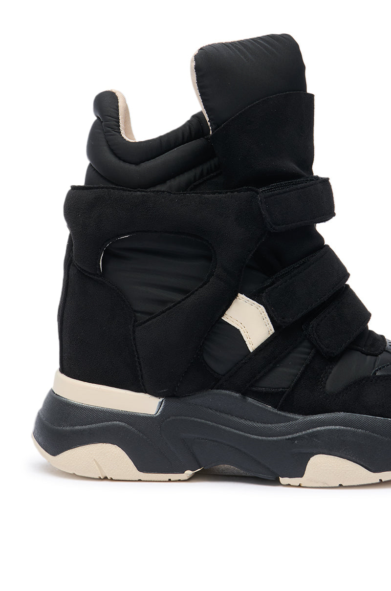 The MARANTO CHUNKY BLACK SNEAKER is a black high-top with padded sections, multiple Velcro straps, a chunky beige and gray-accented sole, and a concealed wedge heel for extra height in a modern sporty design.