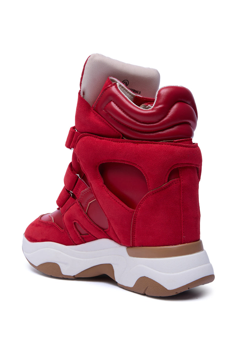 The MARANTO RED WEDGE SNEAKER boasts red suede and shiny faux leather panels, cut-out details, a thick white/tan flatform sole, and padded ankle support, shown from the back-left angle.