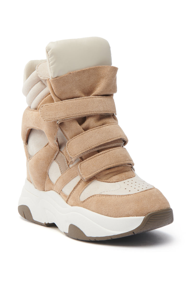 The MARANTO TAUPE WEDGE SNEAKER is a faux leather, beige high-top with a hidden wedge heel, multiple Velcro straps, and cut-out details. It boasts a chunky white sole and padded ankle support, blending sporty and fashion-forward looks.