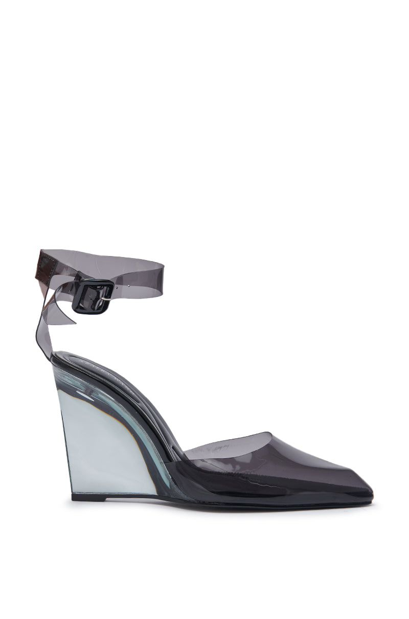 The AZALEA WANG MARCO SMOKE PVC PUMP features a transparent PVC upper, pointed toe, ankle strap with buckle, and smoke-colored wedge heel. Its clear sole and heel deliver a modern and sleek look. 5