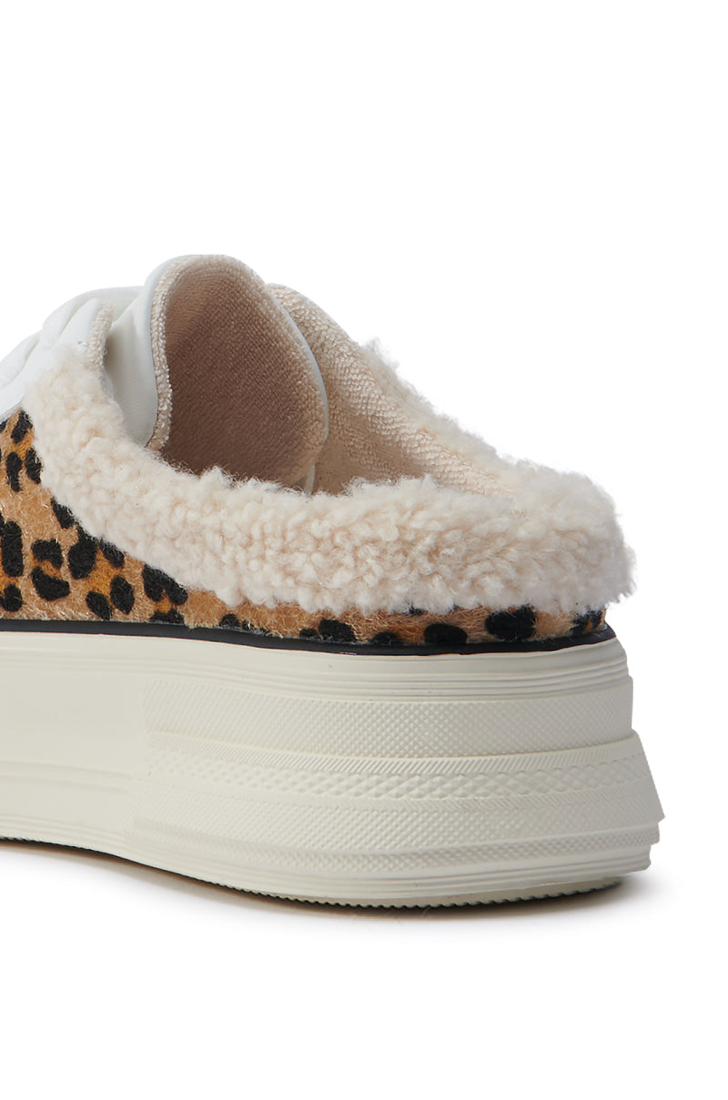 Close-up of the AZALEA WANG MARGARITA FLAT SNEAKER showcasing a cheetah print with a thick, white sole. The upper displays a leopard pattern complemented by a fuzzy, beige lining. This faux leather sneaker offers the convenience of a slip-on style design.