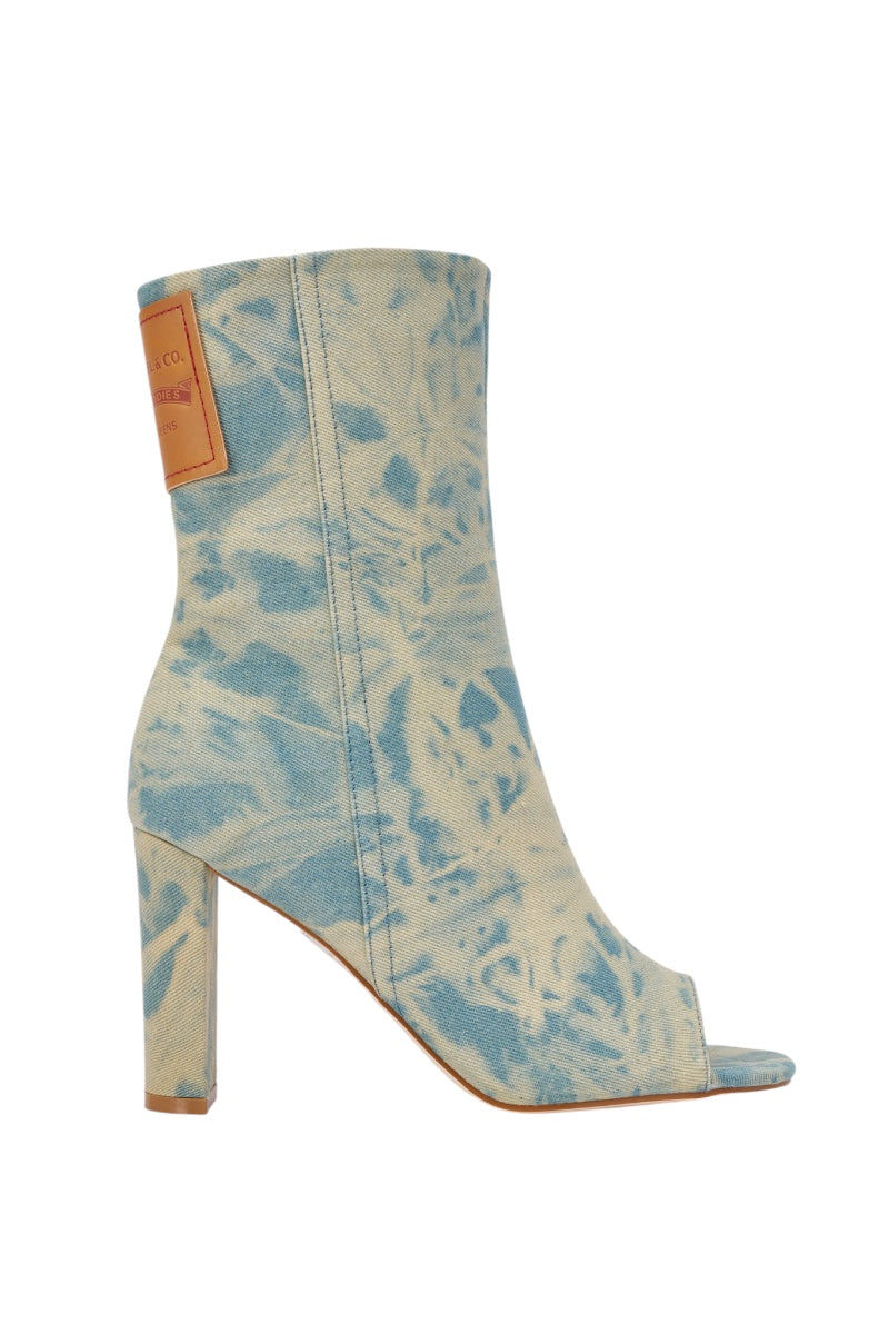 The AKIRA Gold Market Denim Block Open Toe Bootie features a high heel, blue and beige tie-dye design, peep toe, and a rectangular tan patch—an eye-catching addition to your streetwear booties collection.