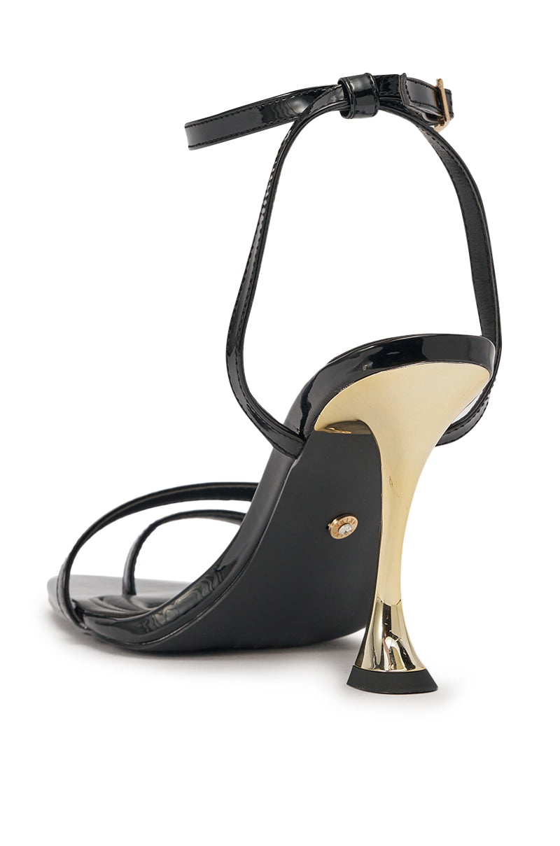 The AKIRA GOLD MARKOVA BLACK POINTED TOE STILETTO features a sleek black faux leather design with a shiny gold stiletto heel and ankle buckle—ideal for a chic evening look, shown from the back on a white background. 5