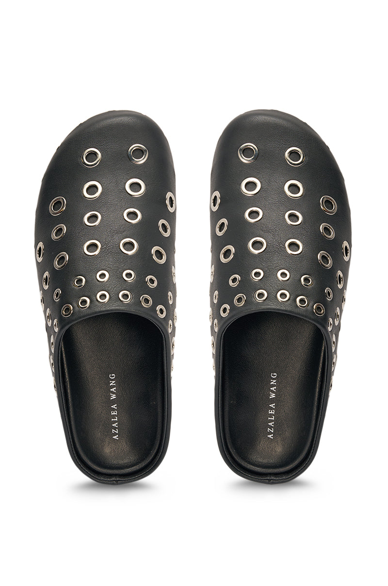 The AZALEA WANG MARSHA BLACK GROMMET DETAIL FLAT features slip-on clogs with multiple silver grommets and insoles labeled "AZALEA WANG," making them a bold, edgy addition to your streetwear shoe collection. 2