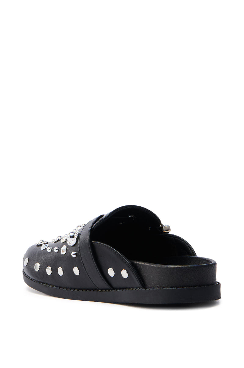 The AZALEA WANG MAULDIN Hardware Embellished Clog in black features silver studs and embellishments, crafted from vegan leather with a flat sole, and is slip-on style. It is positioned at an angle to highlight its design and detailing.