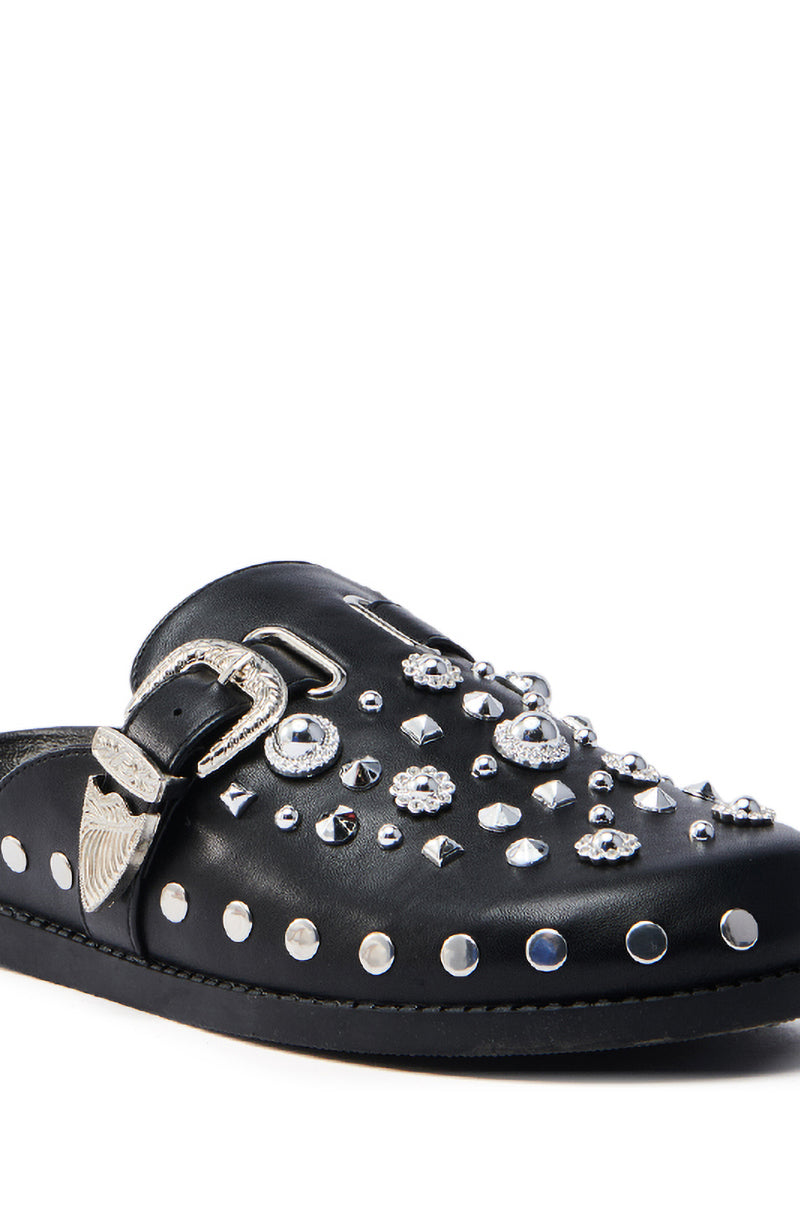 Embrace edgy elegance with the AZALEA WANG MAULDIN HARDWARE EMBELLISHED CLOG IN BLACK. This vegan leather slip-on shoe features silver studs, gemstones, a decorative buckle, wing-like side embellishments, and an almond toe for a contemporary silhouette.