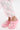 Person wearing light gray pants with pink ribbon bows and AZALEA WANG MAVA PINK PEARL IRIDESCENT FLAT shoes, which feature pearl embellishments and decorative charms, standing on a white surface.