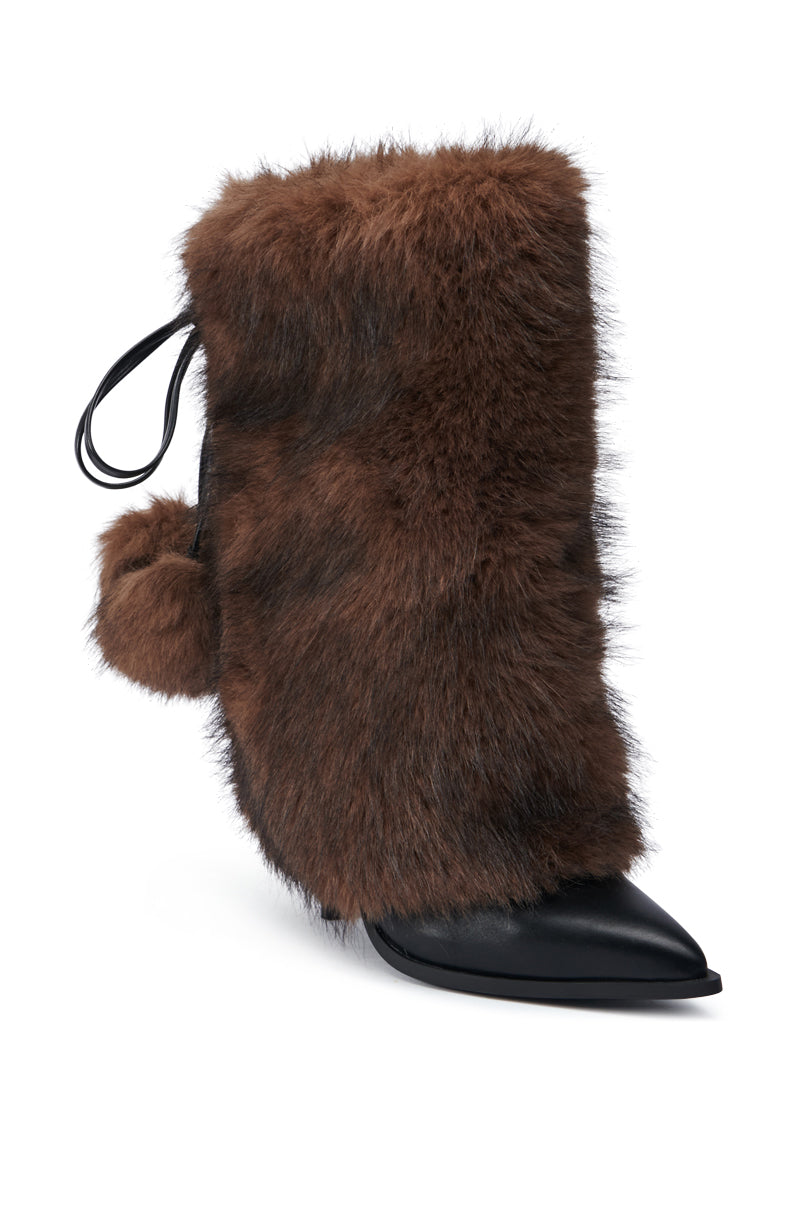 Introducing the AZALEA WANG MAYRA BROWN BOOTIE: A chic faux leather bootie adorned with brown fur on the upper section, accented by a charming fluffy pom-pom on the side. The mid-calf shaft gracefully transitions into a smooth black pointed toe and is perfectly paired with an elegant stiletto heel.