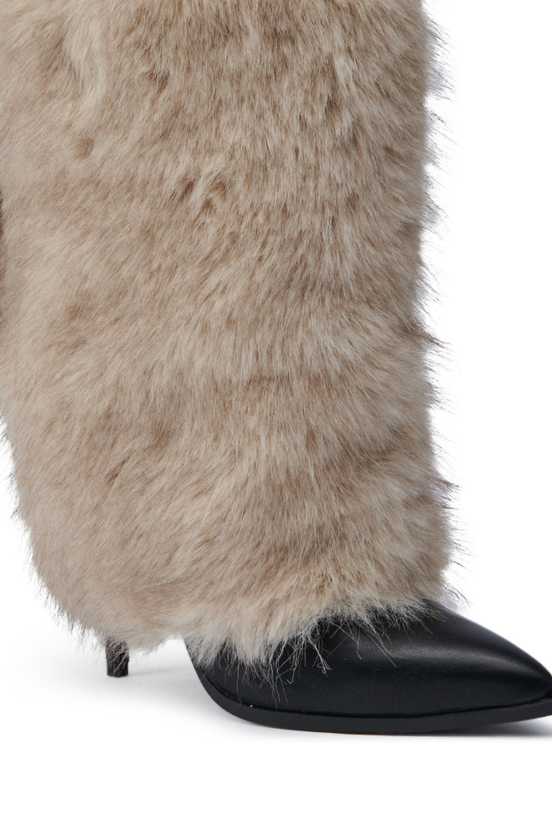 The AZALEA WANG MAYRA TAUPE BOOTIE is elegantly displayed with its beige faux fur enveloping the high-heeled stiletto, complete with a pointed black toe. The textured fur provides a striking contrast to the sleek, shiny finish, accentuating the sophistication of this stylish faux leather bootie.