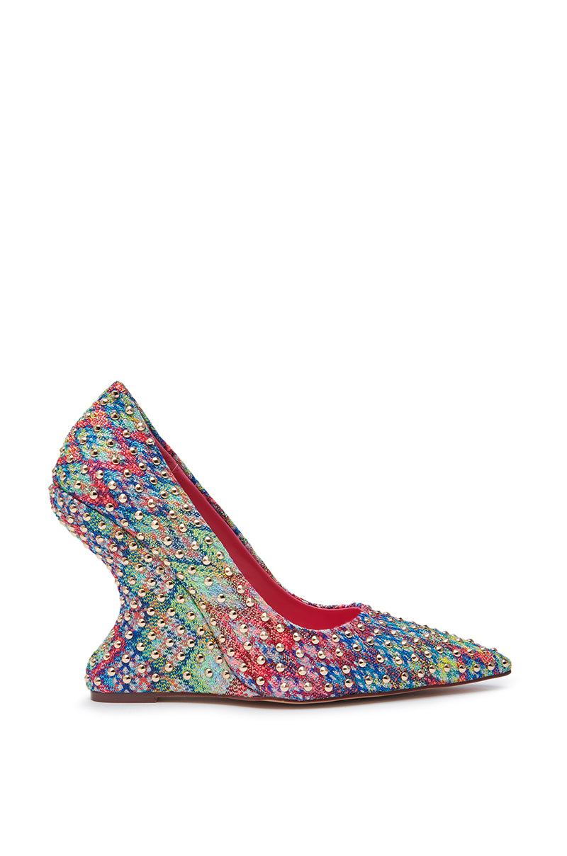 The AZALEA WANG MAYUR MULTI WEDGE PUMP WITH STUD DETAIL features a pointed toe, sculpted curved wedge heel, multicolored rhinestone accents in a vibrant rainbow pattern, and an artistic, eye-catching design.