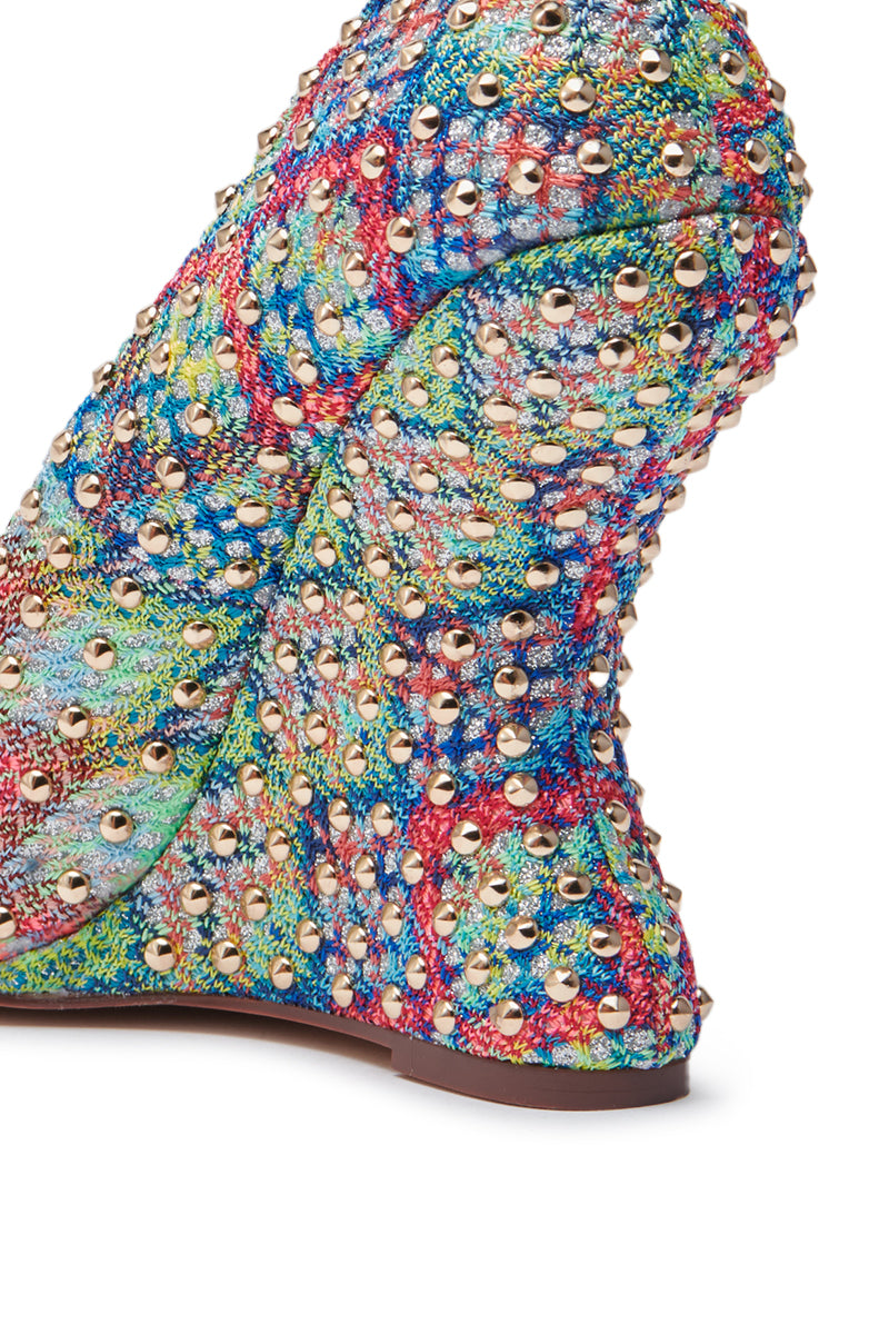 The AZALEA WANG MAYUR MULTI WEDGE PUMP features multicolored textured fabric and gold stud detail, with a chunky heel and intricate studs creating a vibrant, eye-catching pattern.