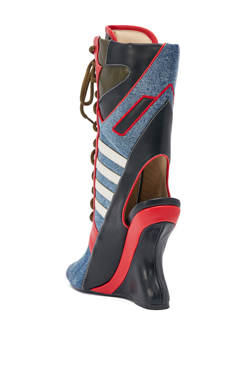 The AKIRA GOLD MAYWEATHER MULTI SPORTY LOOK WEDGE BOOTIE features a high wedge heel, denim panels, black and red accents, gray stripes, olive green details, tan interior, faux leather trim, lace-up front, and futuristic styling.