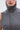 A close-up of a person wearing the DONT GIVE UP MOCK NECK KNIT MAXI DRESS, featuring a sleeveless gray design with body-contouring seams. Only their lower face and neck are visible; they wear hoop earrings and neutral lipstick.