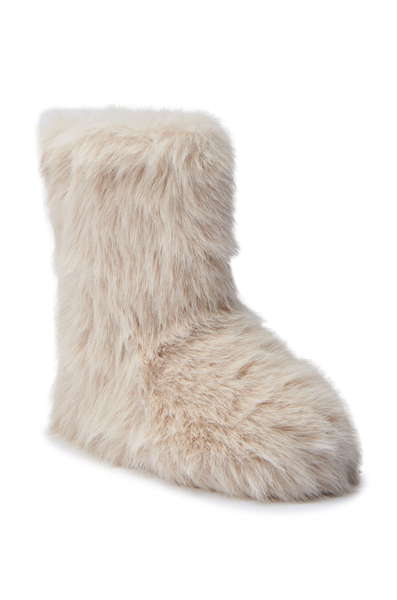 The MELANIE BEIGE FURRY BOOTIE is a fuzzy, cream-colored faux fur bootie boasting a fluffy exterior. Crafted for ultimate comfort and warmth, it features a high ankle section and a slightly pointed toe. The plain white background accentuates its inviting texture and cozy design.